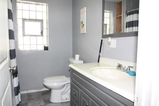 a bathroom with a sink toilet and window