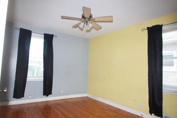 a view of a room with wooden floor and windows