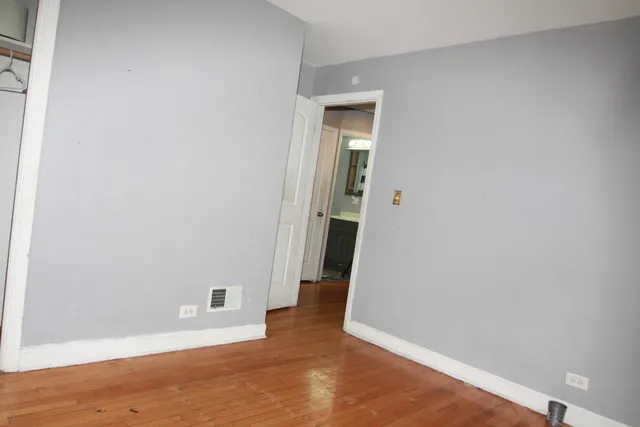 an empty room with wooden floor and entrance