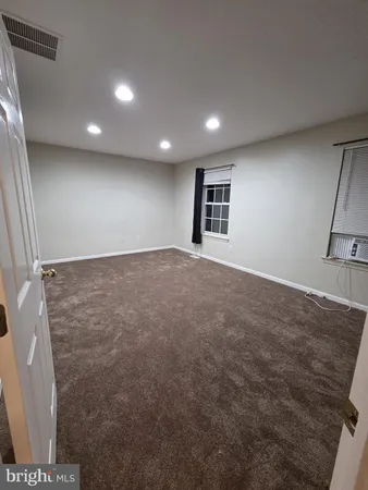 an empty room with wooden floor and entrance