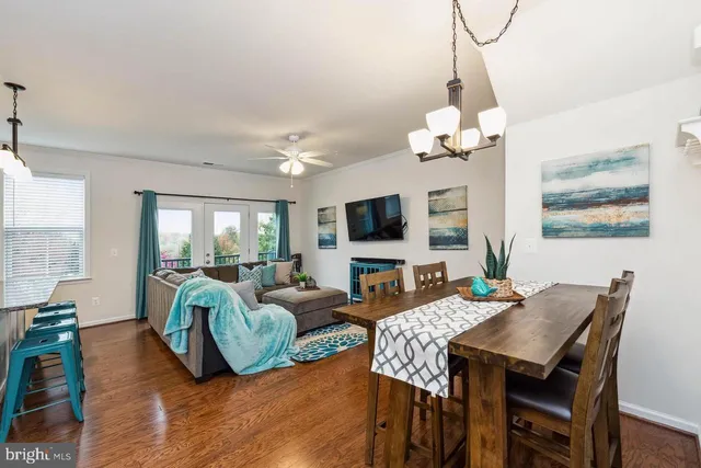 a view of a dining room with furniture a chandelier and wooden floor