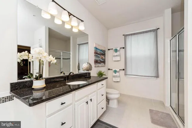 a bathroom with a double vanity sink a toilet and a mirror