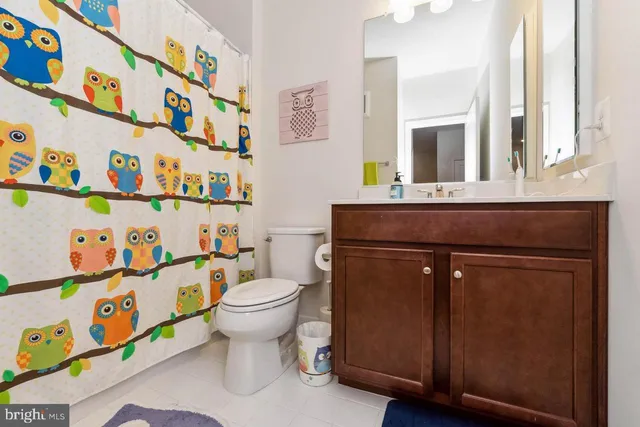 a bathroom with a sink a toilet and a shower curtain