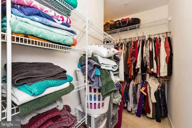a view of walk in closet with clothes and shoes