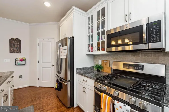 a kitchen with stainless steel appliances granite countertop a stove microwave and refrigerator