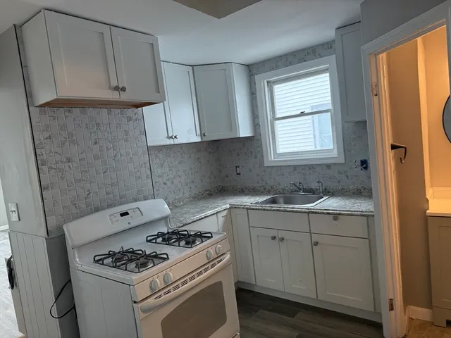 a kitchen with cabinets appliances and a window