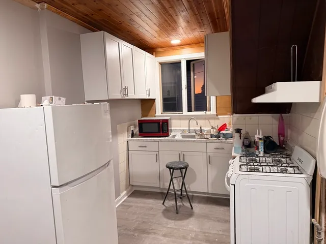 a room with a refrigerator and a stove top oven