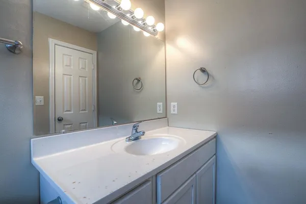 a bathroom with a sink vanity and a mirror