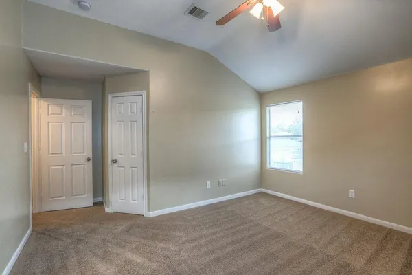 en empty room with windows and chandelier fan
