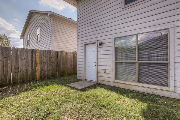 a view of backyard with tub and wooden fence