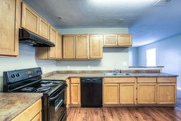 a kitchen with stainless steel appliances granite countertop a stove a sink and a microwave