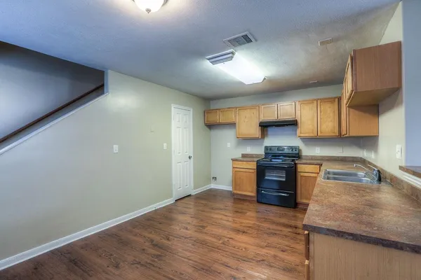 a kitchen with stainless steel appliances granite countertop a stove a sink and a refrigerator