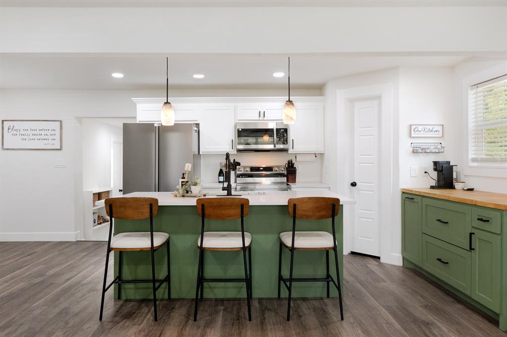 205 Oregon Avenue Azle, TX 76020 - Photo 11 of 40 Kitchen featuring green cabinetry, a center island with sink, and recessed lighting