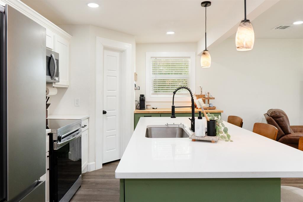 205 Oregon Avenue Azle, TX 76020 - Photo 13 of 40 Kitchen featuring green cabinetry, white cabinets, a breakfast bar,