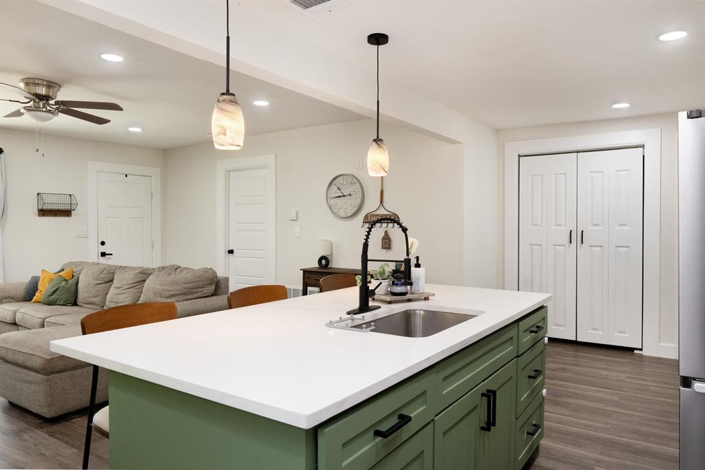205 Oregon Avenue Azle, TX 76020 - Photo 14 of 40 Kitchen featuring green cabinets, recessed lighting, hanging light fixtures, and a kitchen bar