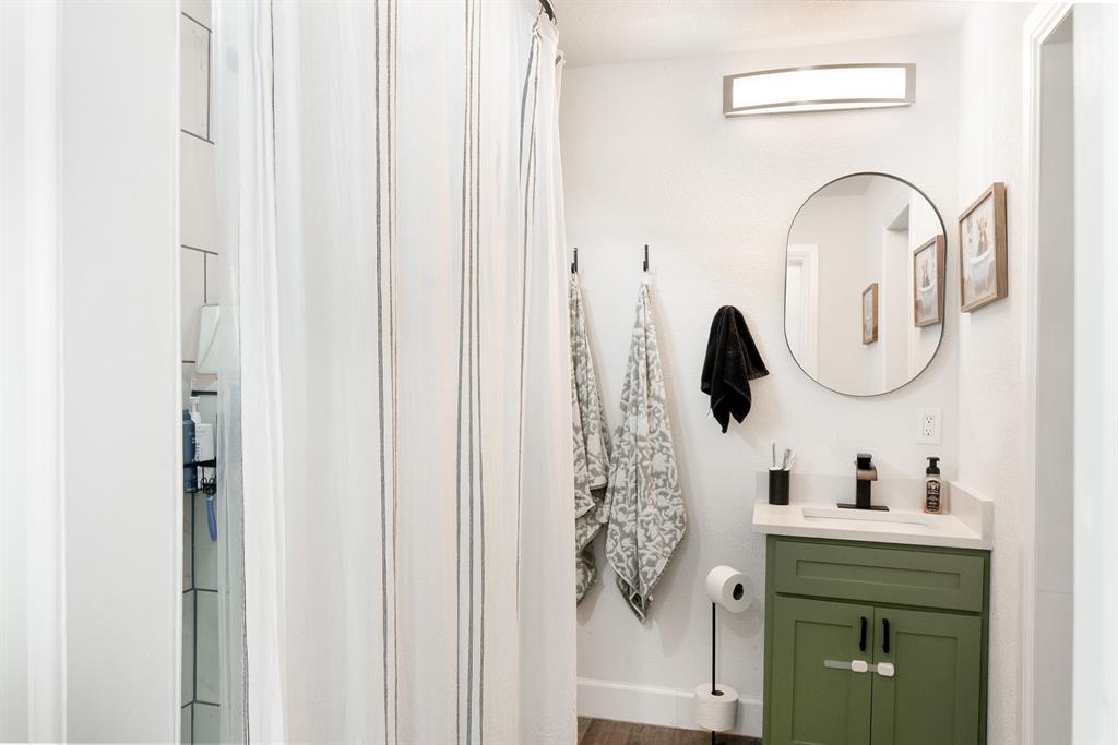 205 Oregon Avenue Azle, TX 76020 - Photo 19 of 40 Ensuite Bathroom with a stall shower, vanity, and dark wood-style floors