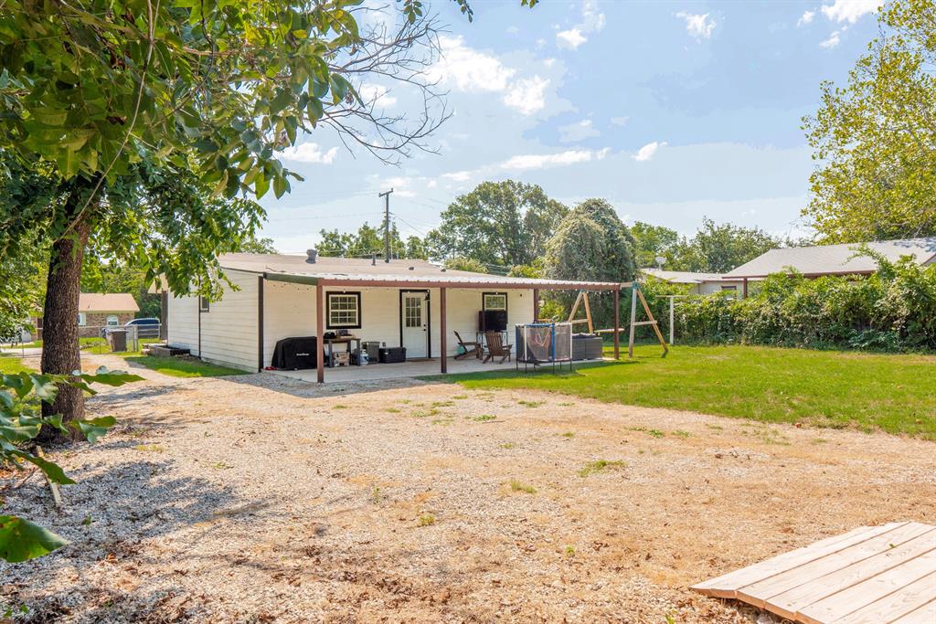 205 Oregon Avenue Azle, TX 76020 - Photo 32 of 40 Rear view of property featuring a patio area and a lawn