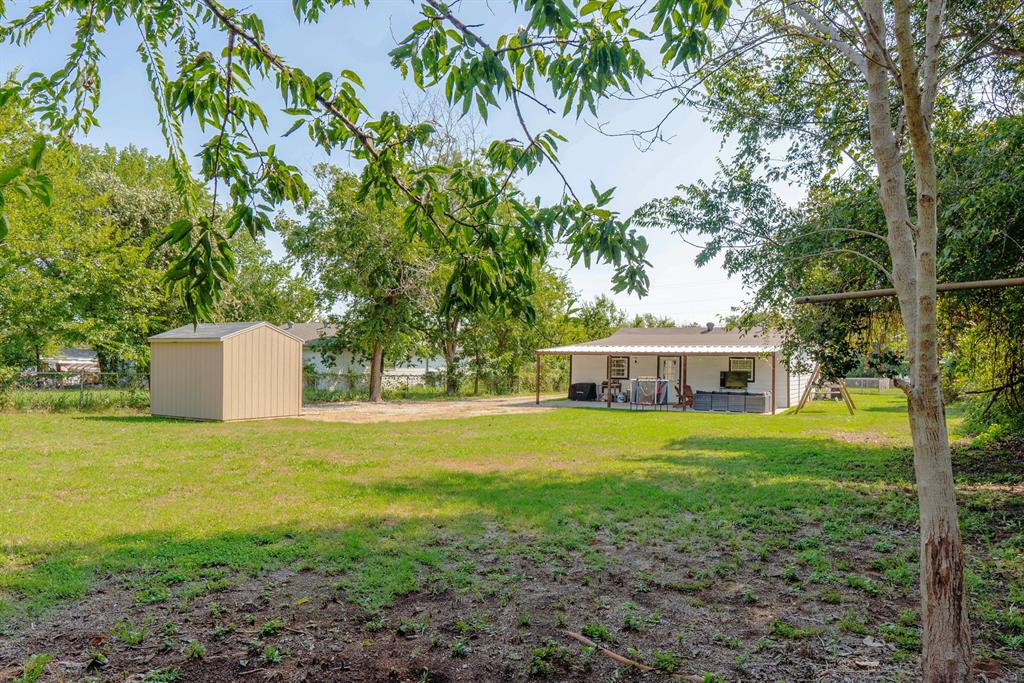 205 Oregon Avenue Azle, TX 76020 - Photo 35 of 40 View of green lawn with a patio and a shed