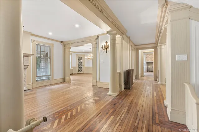 a view of a hallway with wooden floor and furniture