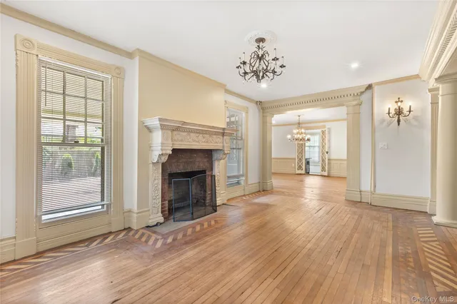 wooden floor fireplace and windows in an empty room