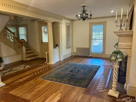a very nice looking room with wooden floor and a chandelier