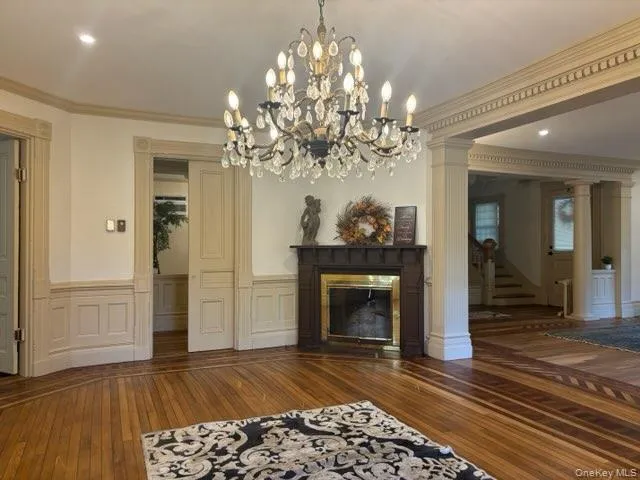 a living room with a fireplace and chandelier