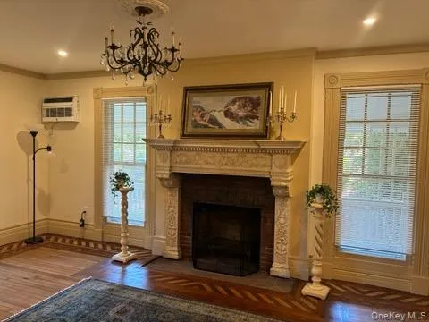 a living room with a fireplace windows and a chandelier