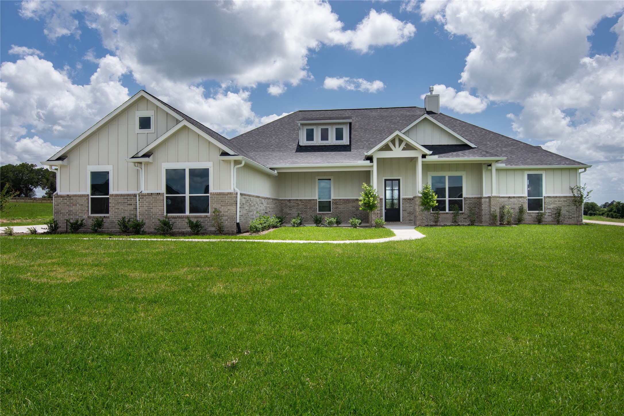a front view of a house with a garden and yard