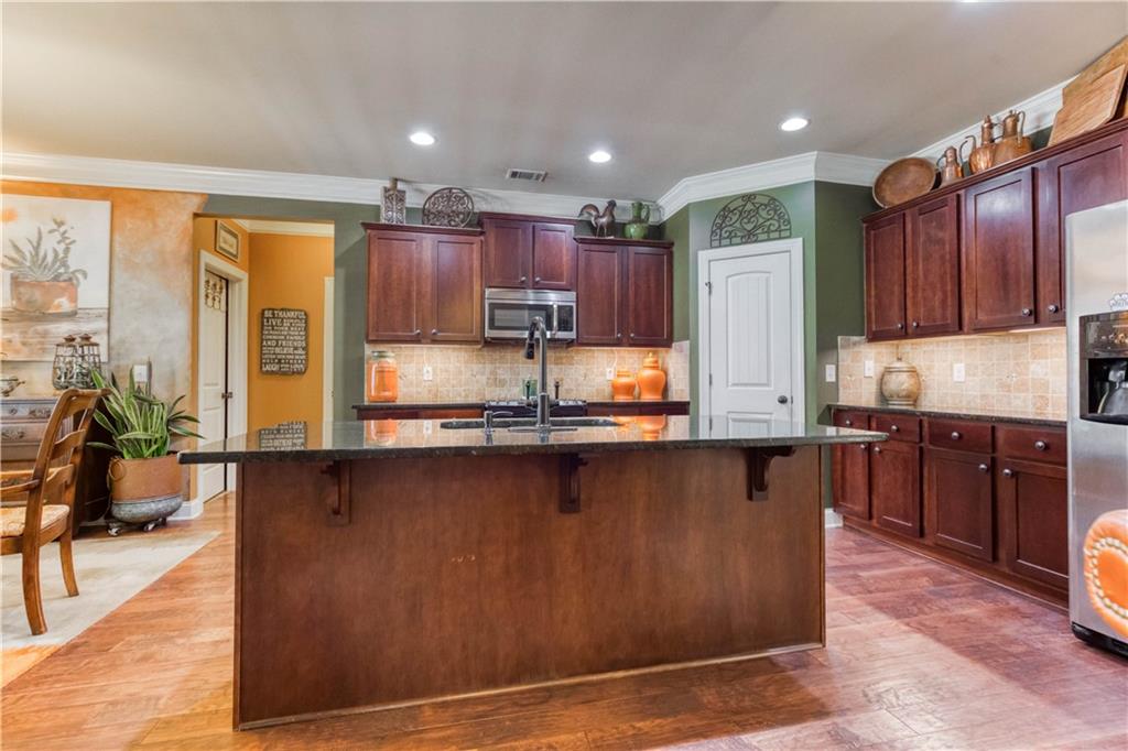 1461 Bradford Lane Monroe, GA 30656 - Photo 18 of 66 a kitchen with stainless steel appliances granite countertop a refrigerator a stove a sink and dishwasher with wooden cabinets