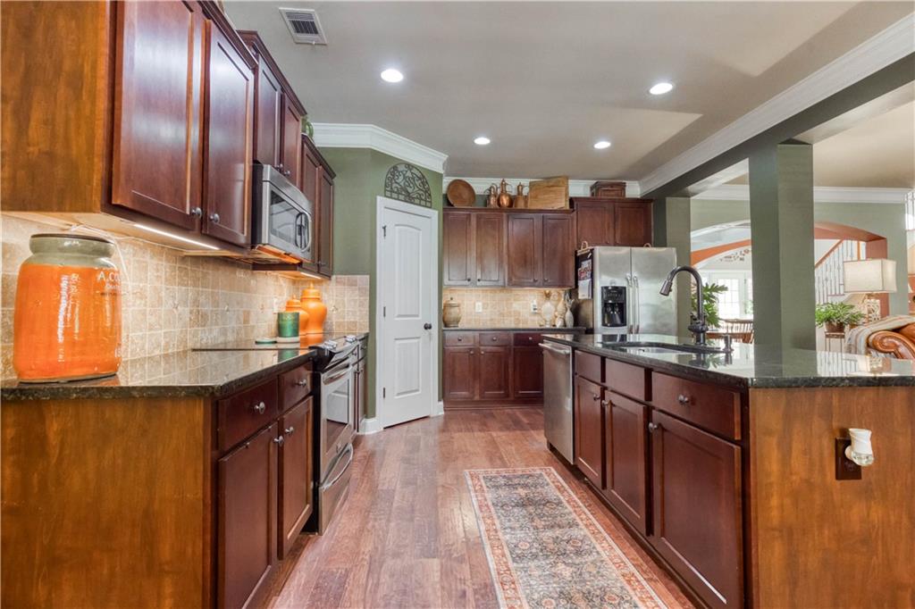 1461 Bradford Lane Monroe, GA 30656 - Photo 20 of 66 a kitchen with stainless steel appliances granite countertop lots of counter top space a sink and cabinets