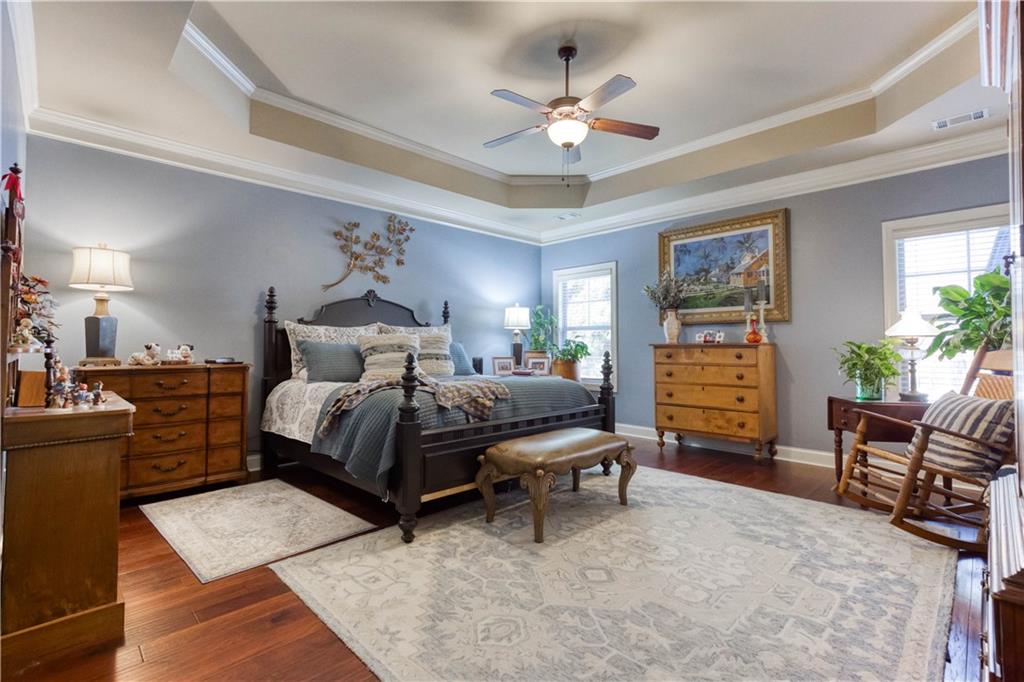 1461 Bradford Lane Monroe, GA 30656 - Photo 26 of 66 a bedroom with a bed a chandelier and a dresser