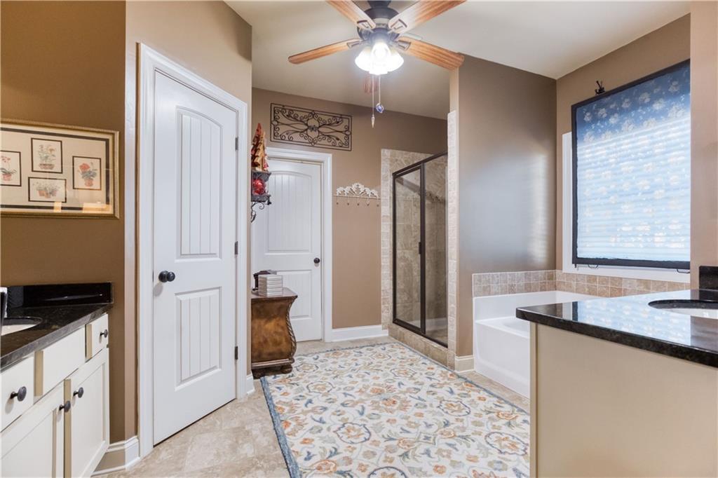 1461 Bradford Lane Monroe, GA 30656 - Photo 30 of 66 a spacious bathroom with a granite countertop sink and a mirror
