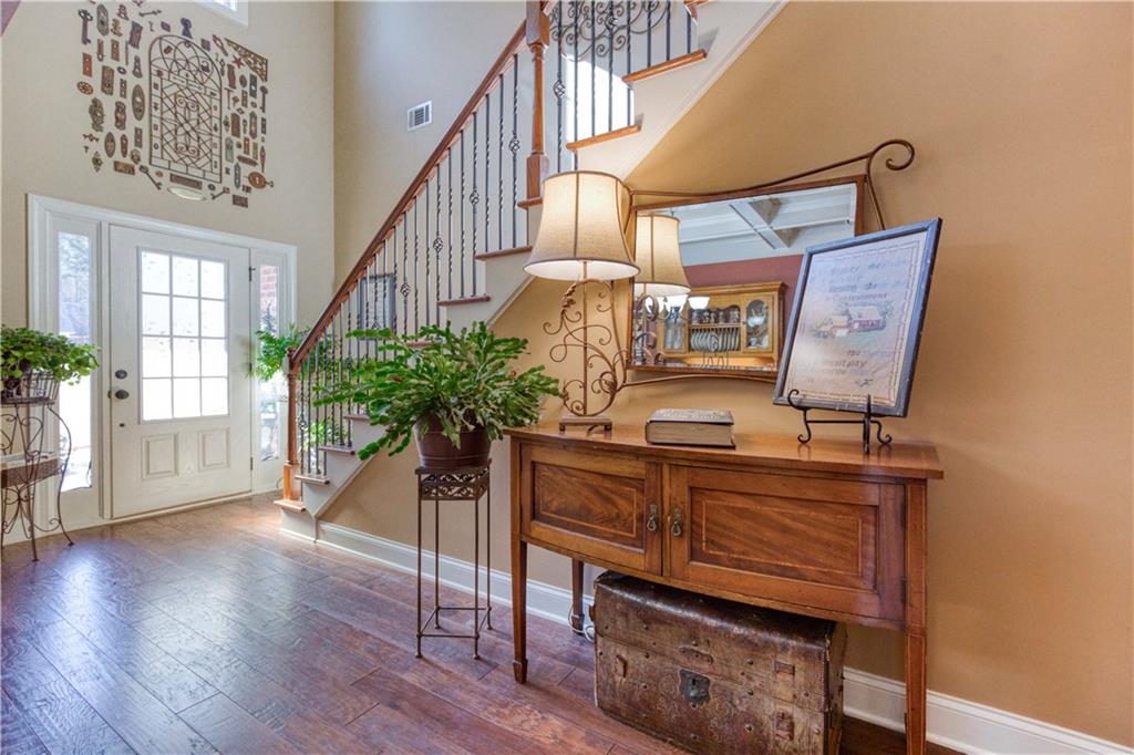 1461 Bradford Lane Monroe, GA 30656 - Photo 7 of 66 a view of a hallway with wooden floor windows and a chandelier
