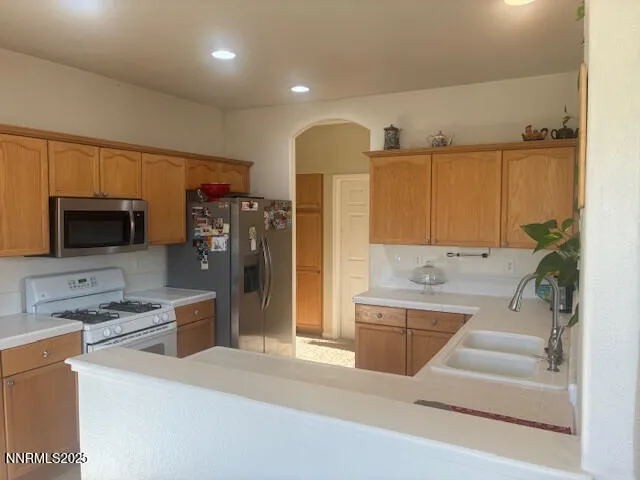 a kitchen with stainless steel appliances kitchen island granite countertop a refrigerator and a sink