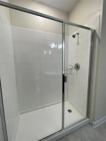 a bathroom with a glass shower door and a window