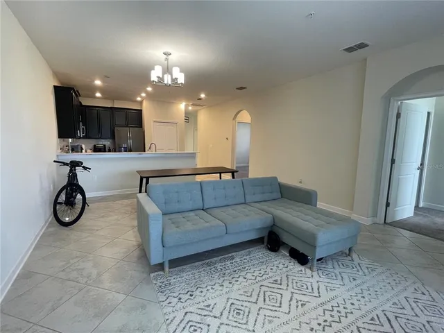 a living room with furniture a clock and a chandelier