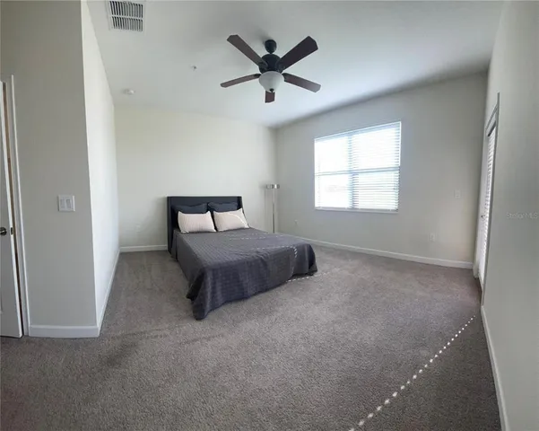 a bed room with a bed and a ceiling fan
