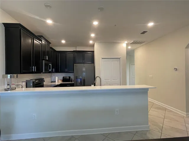 a large white kitchen with a sink and dishwasher