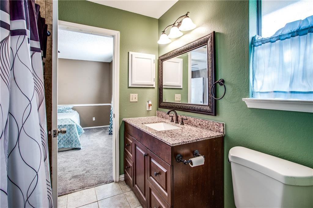 6817 Haltom Road Fort Worth, TX 76137 - Photo 5 of 25 Bathroom featuring a vanity with a granite countertop, undermount sink, and dark wood cabinetry
