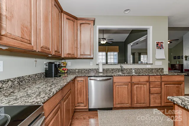a kitchen with stainless steel appliances granite countertop a sink stove and cabinets