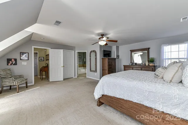 a spacious bedroom with a bed and a chandelier