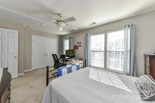 a bedroom with a bed and a large window