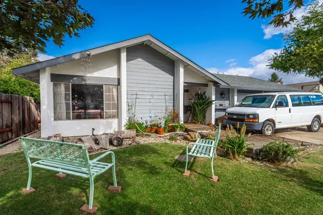 a view of a house with backyard sitting area and garden