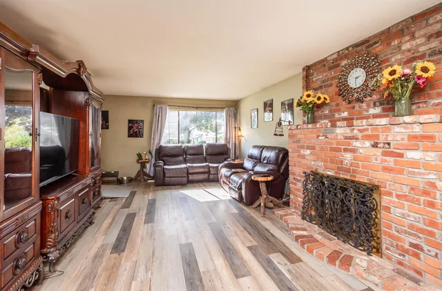 a kitchen with stainless steel appliances kitchen island granite countertop a table chairs in it and wooden floors