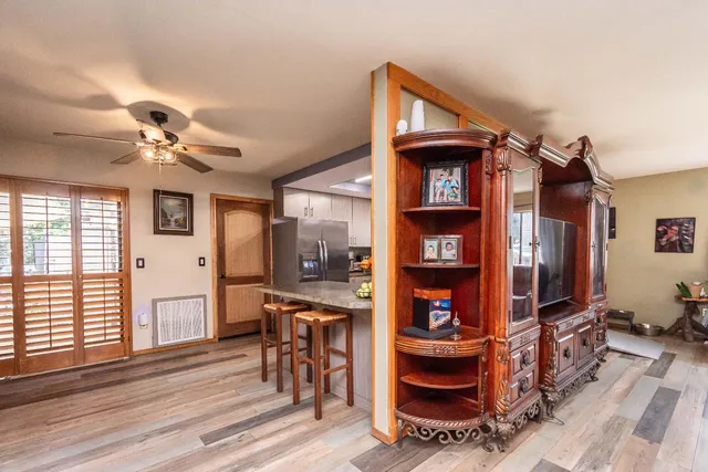 a bedroom with furniture a flat screen tv and a window