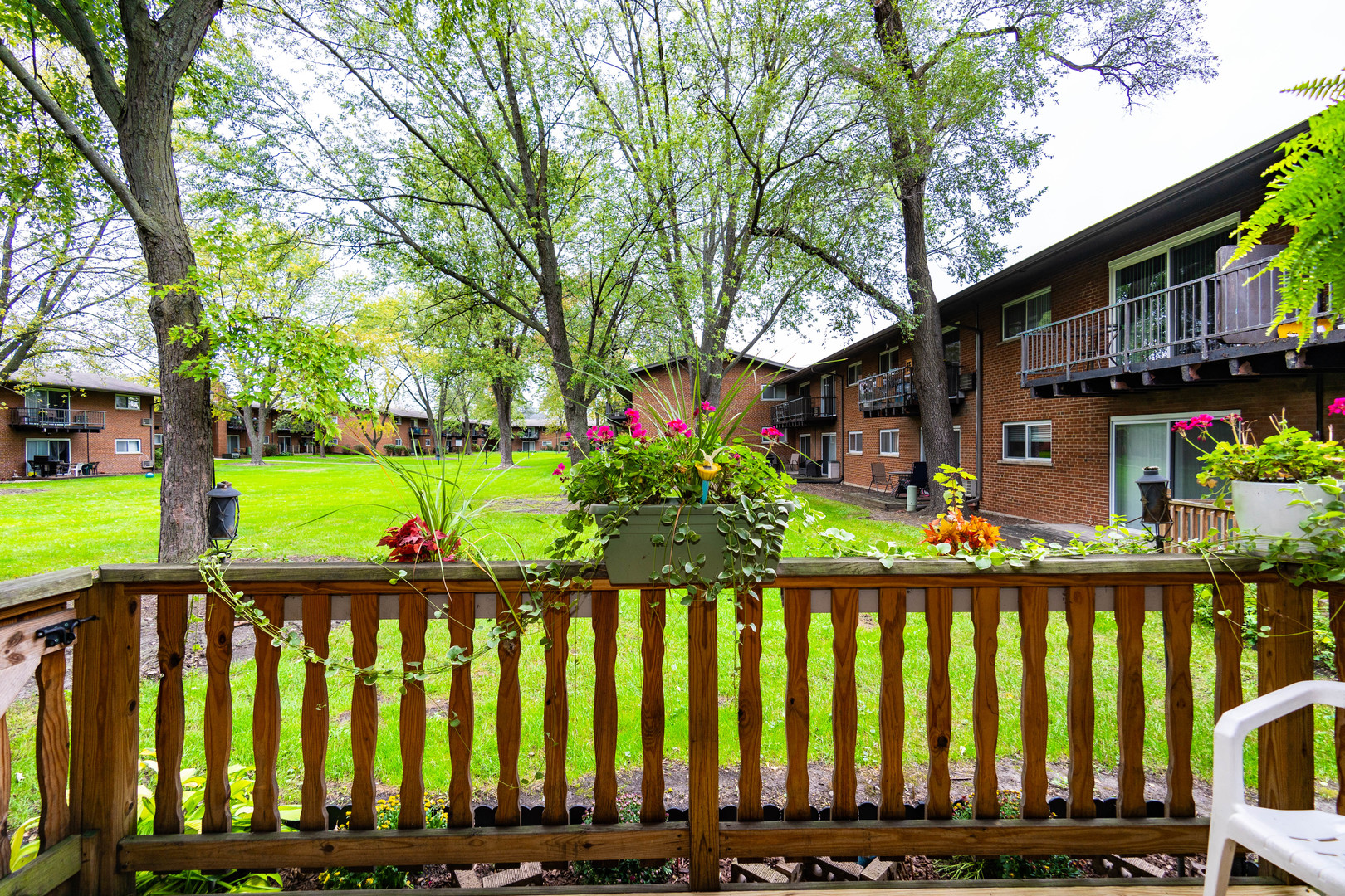 1480 Busse Road, Unit 1D Mount Prospect, IL 60056 - Photo 25 of 34 a front view of a house with a yard table and chairs