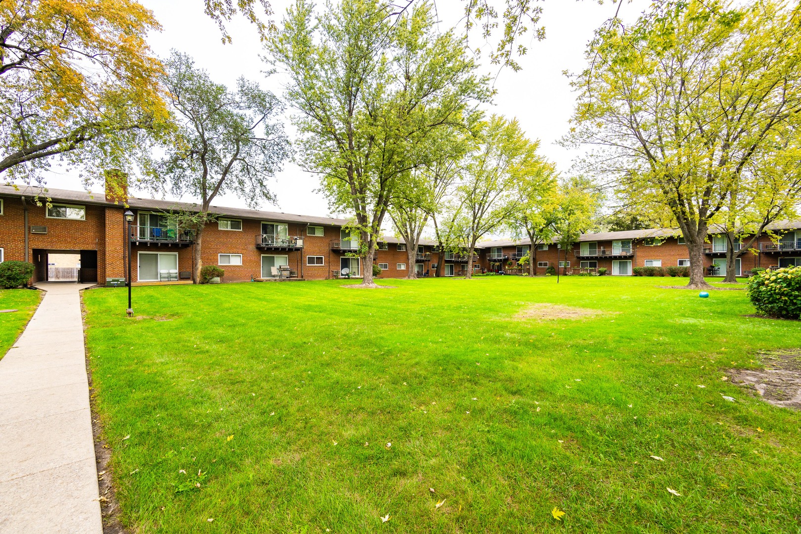 1480 Busse Road, Unit 1D Mount Prospect, IL 60056 - Photo 28 of 34 a view of a house with a big yard and large trees