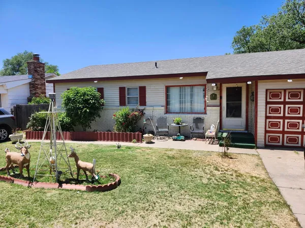 a backyard of a house with yard table and chairs