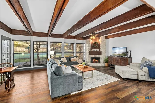 a living room with furniture floor to ceiling window and wooden floor