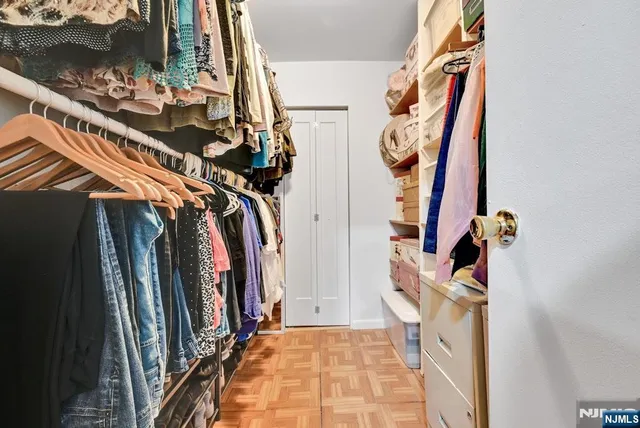 a view of walk in closet with clothes and shoes